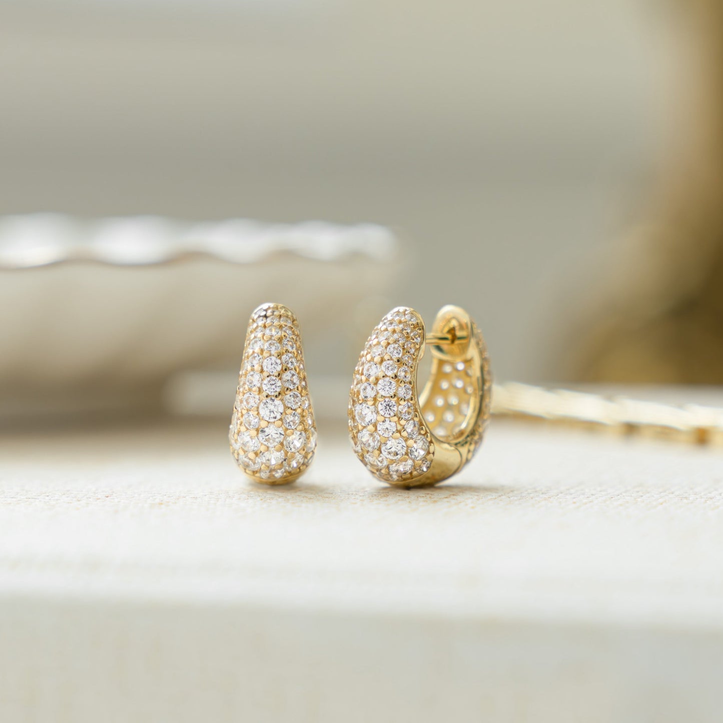 closeup image of statement earrings with 14k gold plating and chunky hoop design