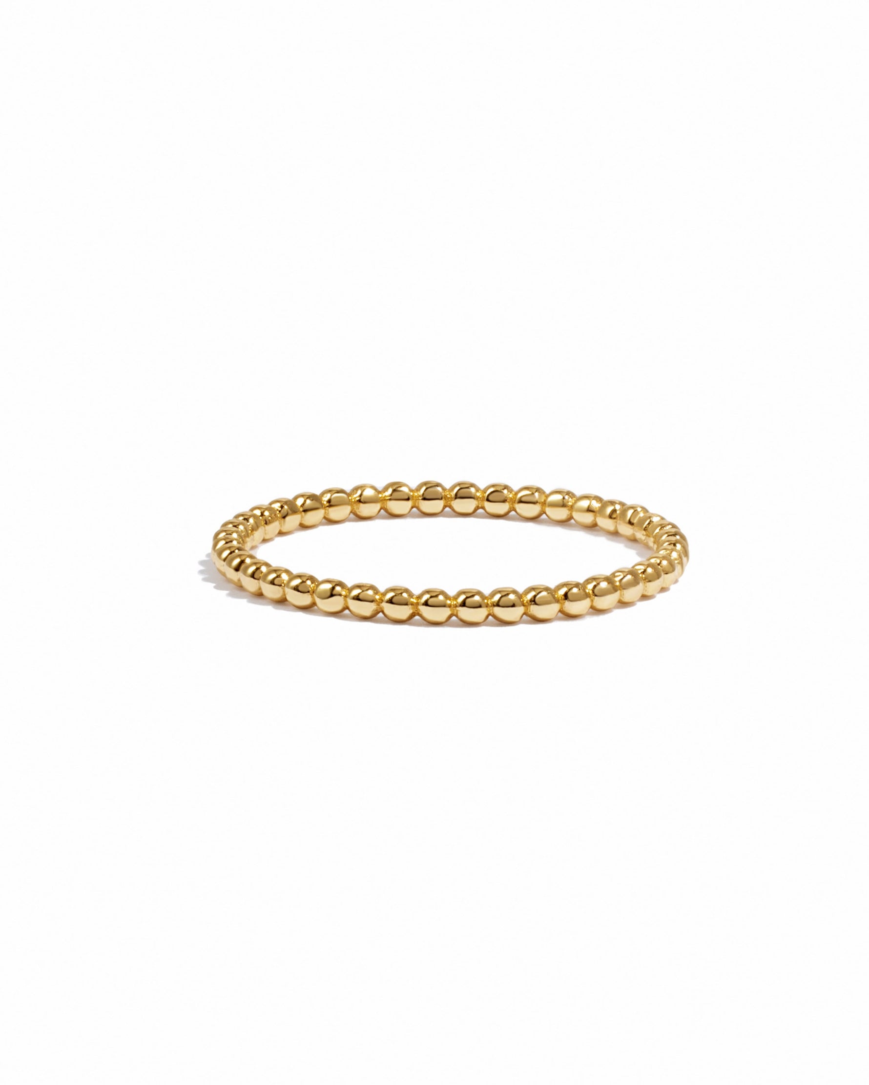 Gold beaded ring on a white background