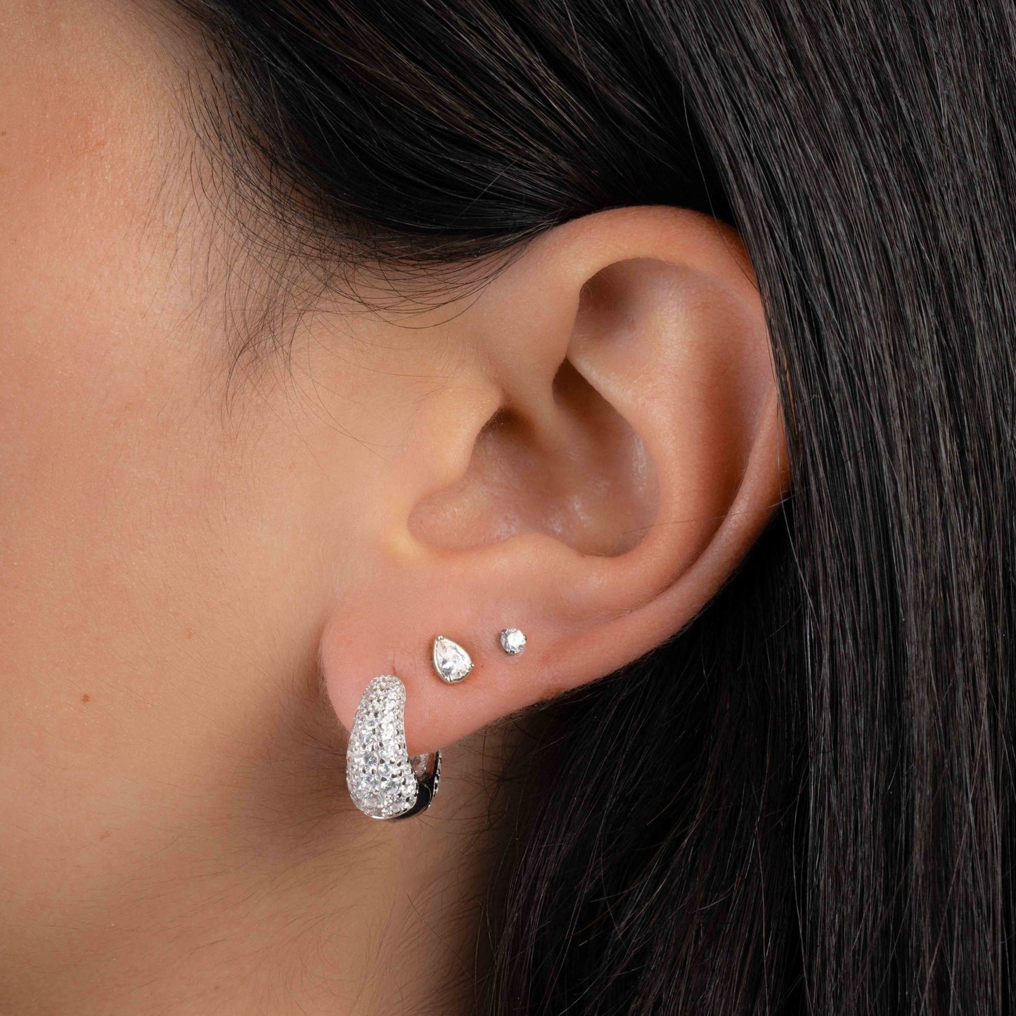 Model wearing silver hoops with chunky hoop earring design and cubic zirconia diamonds