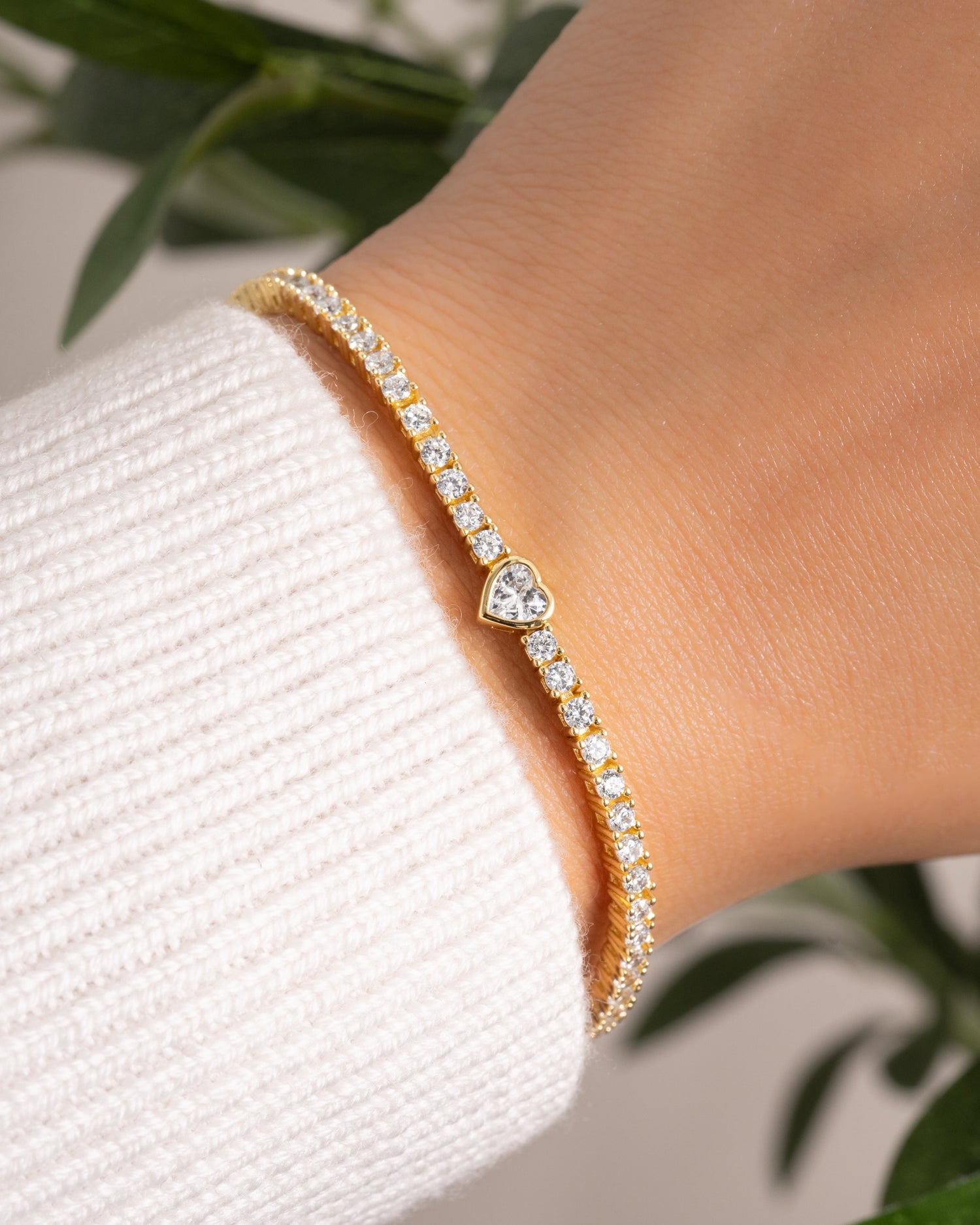 Gold bracelet with heart-shaped gemstone on a tennis bracelet