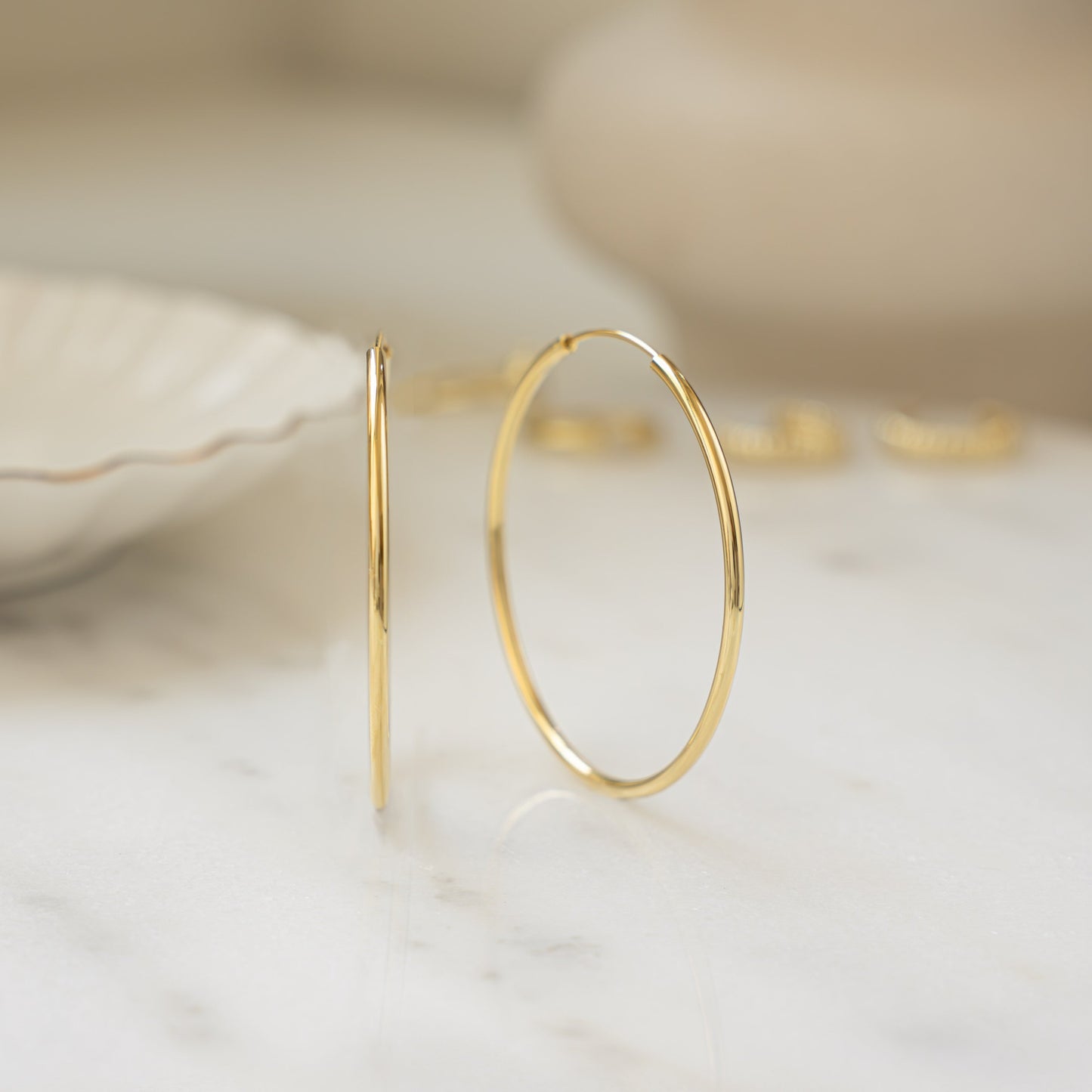 closeup image of skinny gold hoop earrings