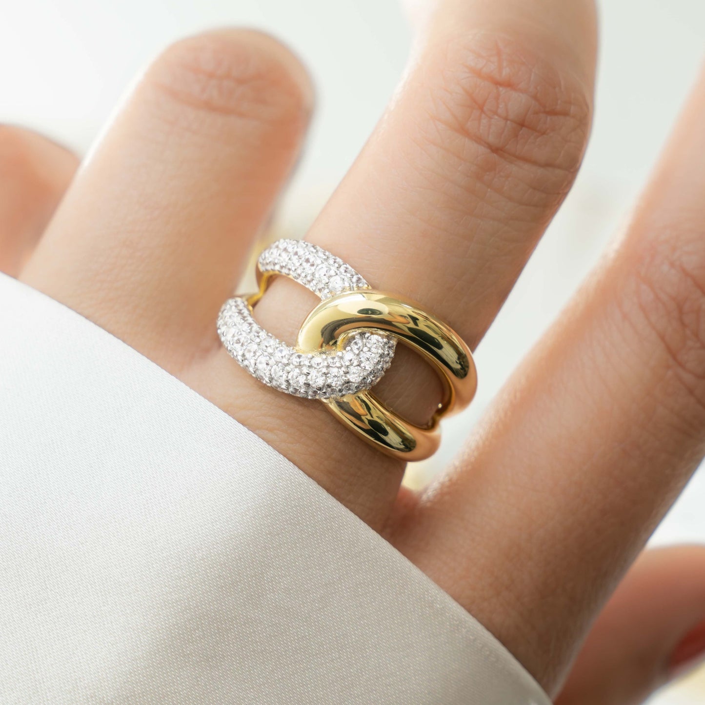 Model wearing gold two tone statement ring with criss cross ring design