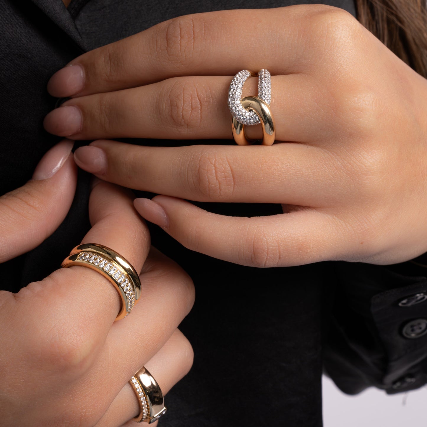 Model wearing mixed metal statement rings featuring two tone ring with criss cross ring design