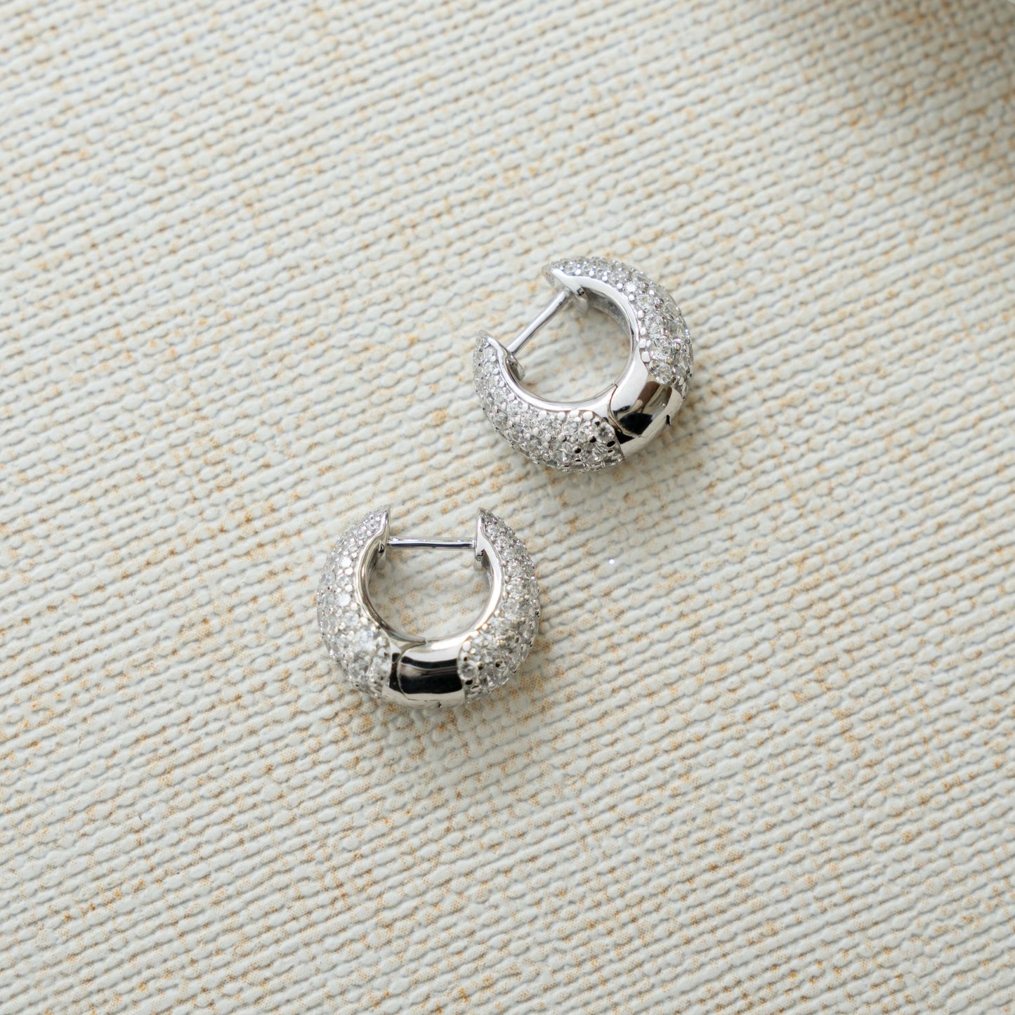 closeup image of silver hoops with chunky hoop design and cubic zirconia diamonds