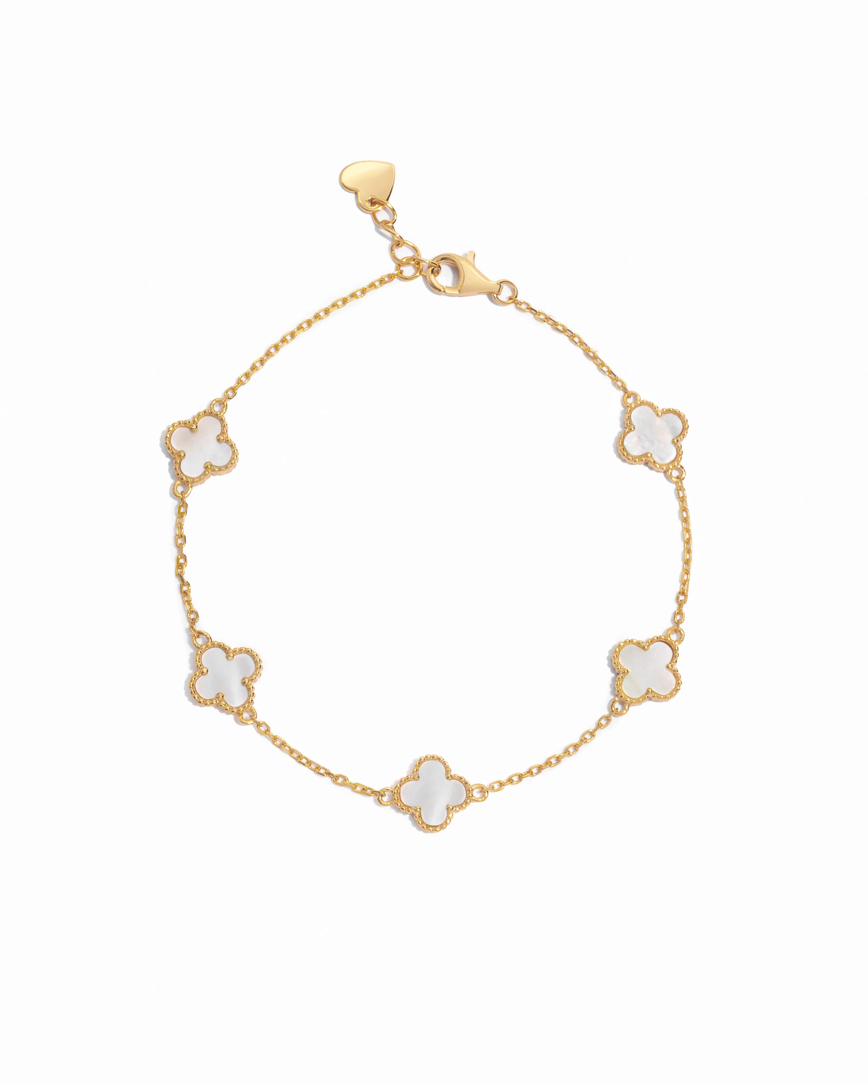 closeup image of a gold, mother of pearl four leaf clover charm bracelet against a white background