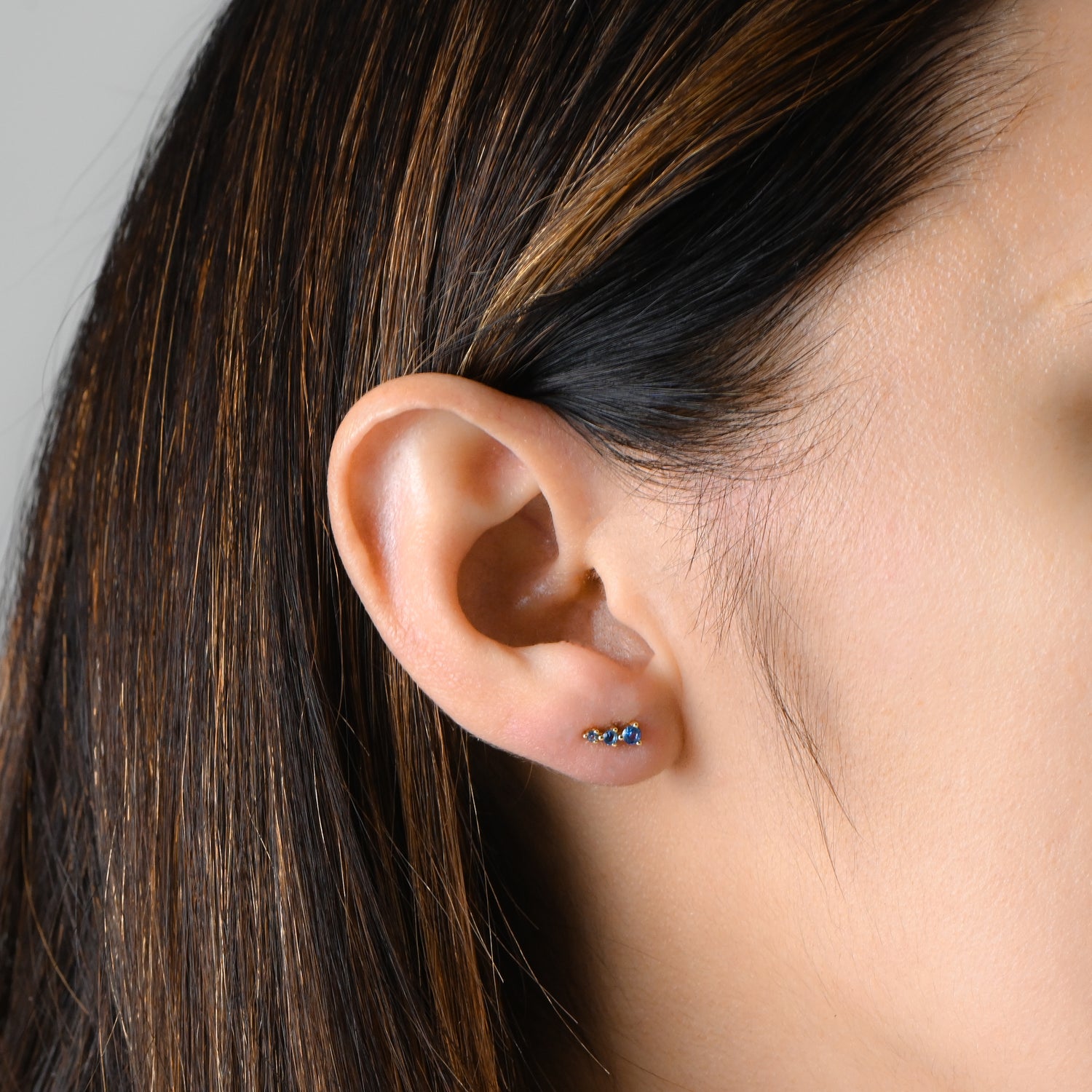 Model wearing gold and aquamarine ear climber stud.