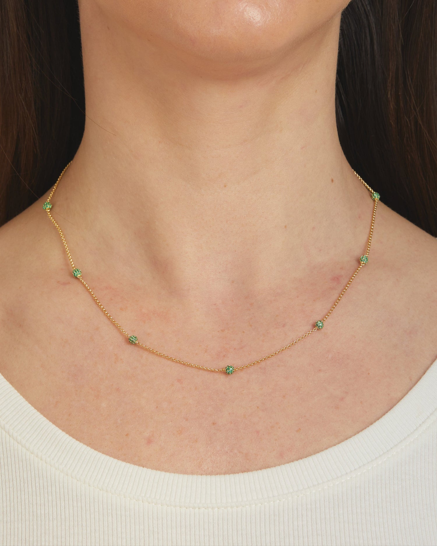 Model wearing emerald ball beaded necklace.