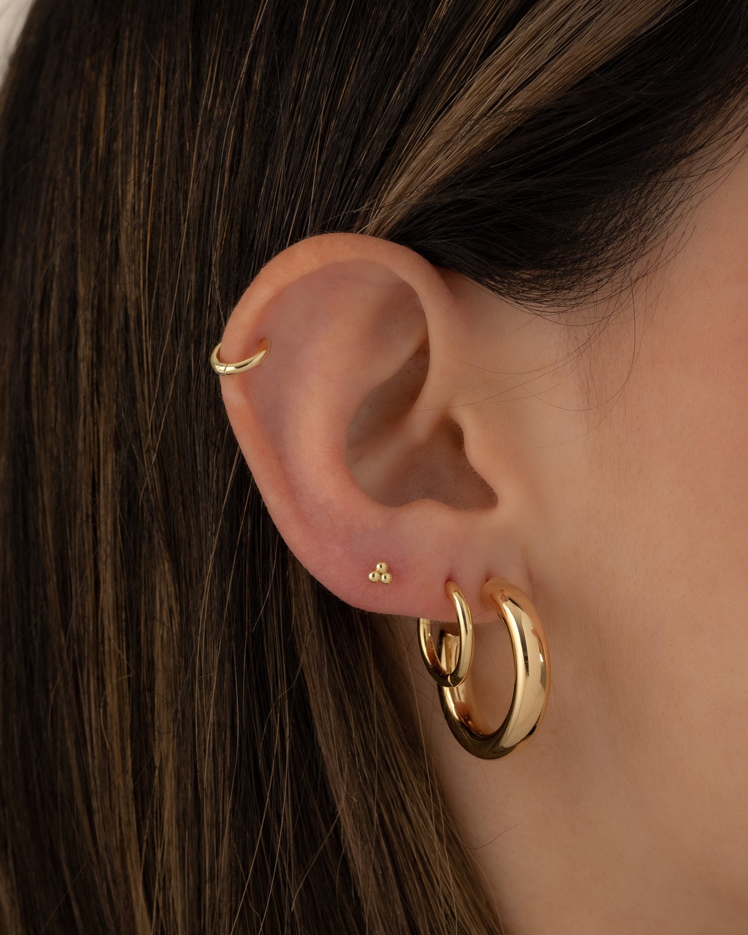 Model wearing everyday gold hoop earring stack.