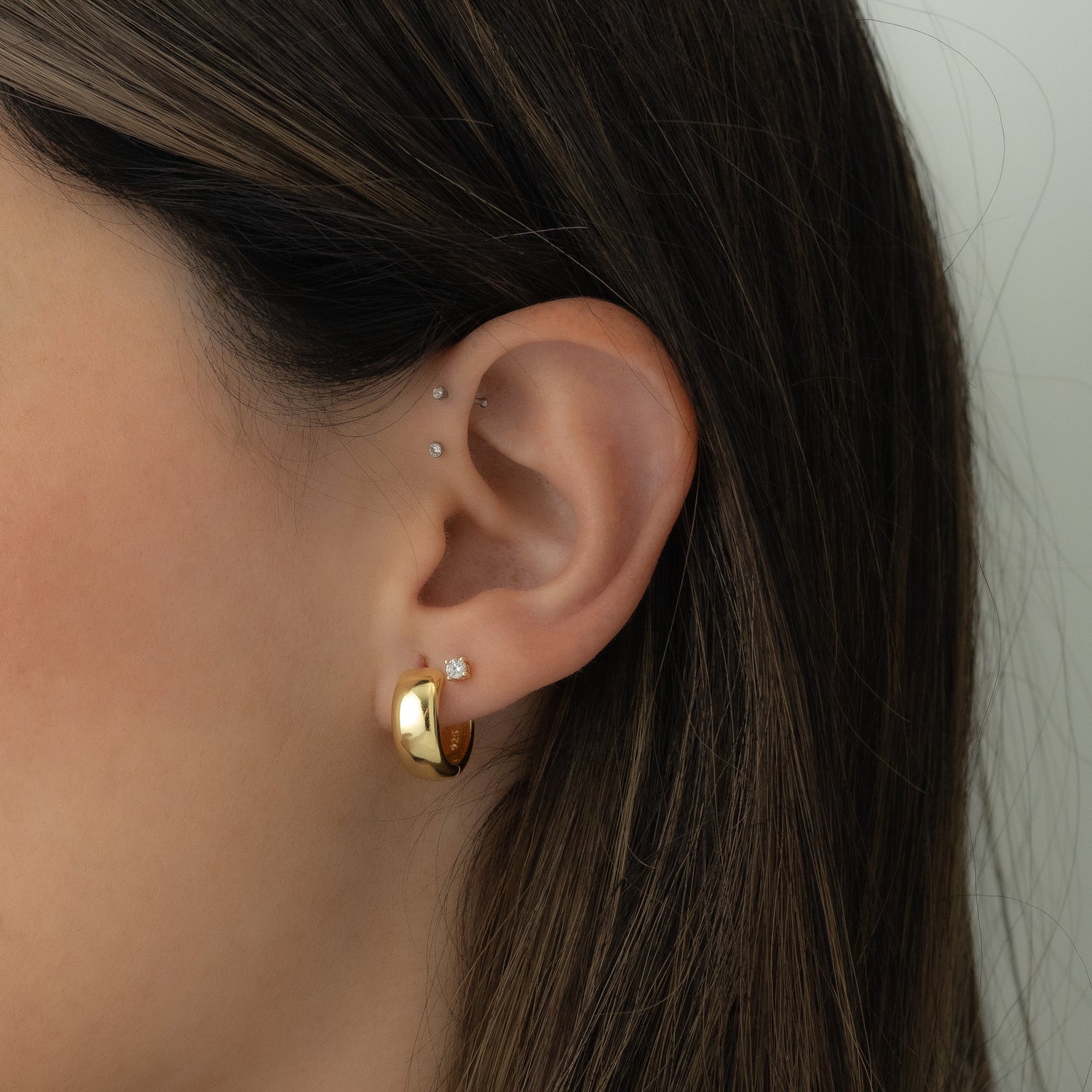 gold hoop earrings and a small stud earring