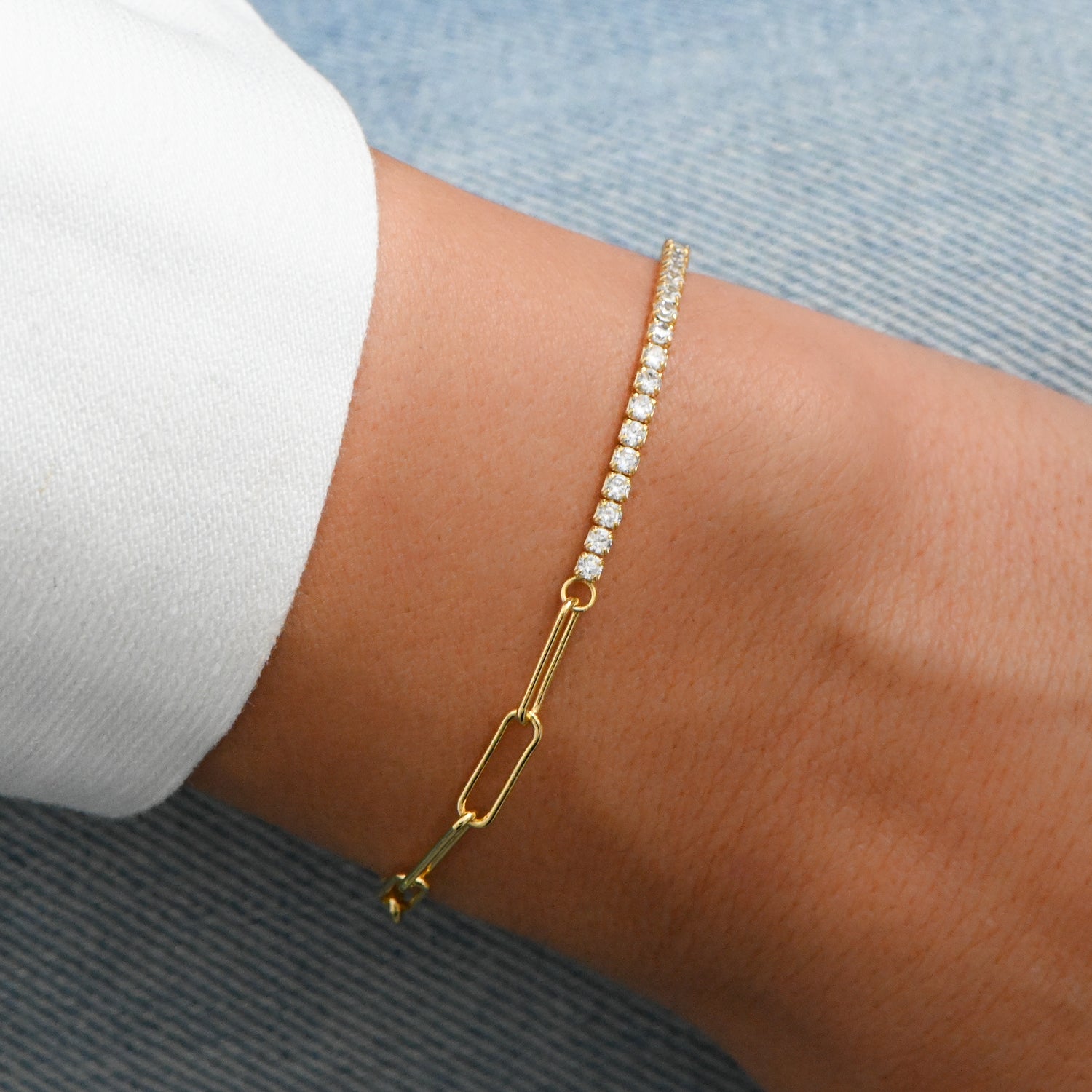 closeup image of gold bracelet with tennis chain and paperclip chain