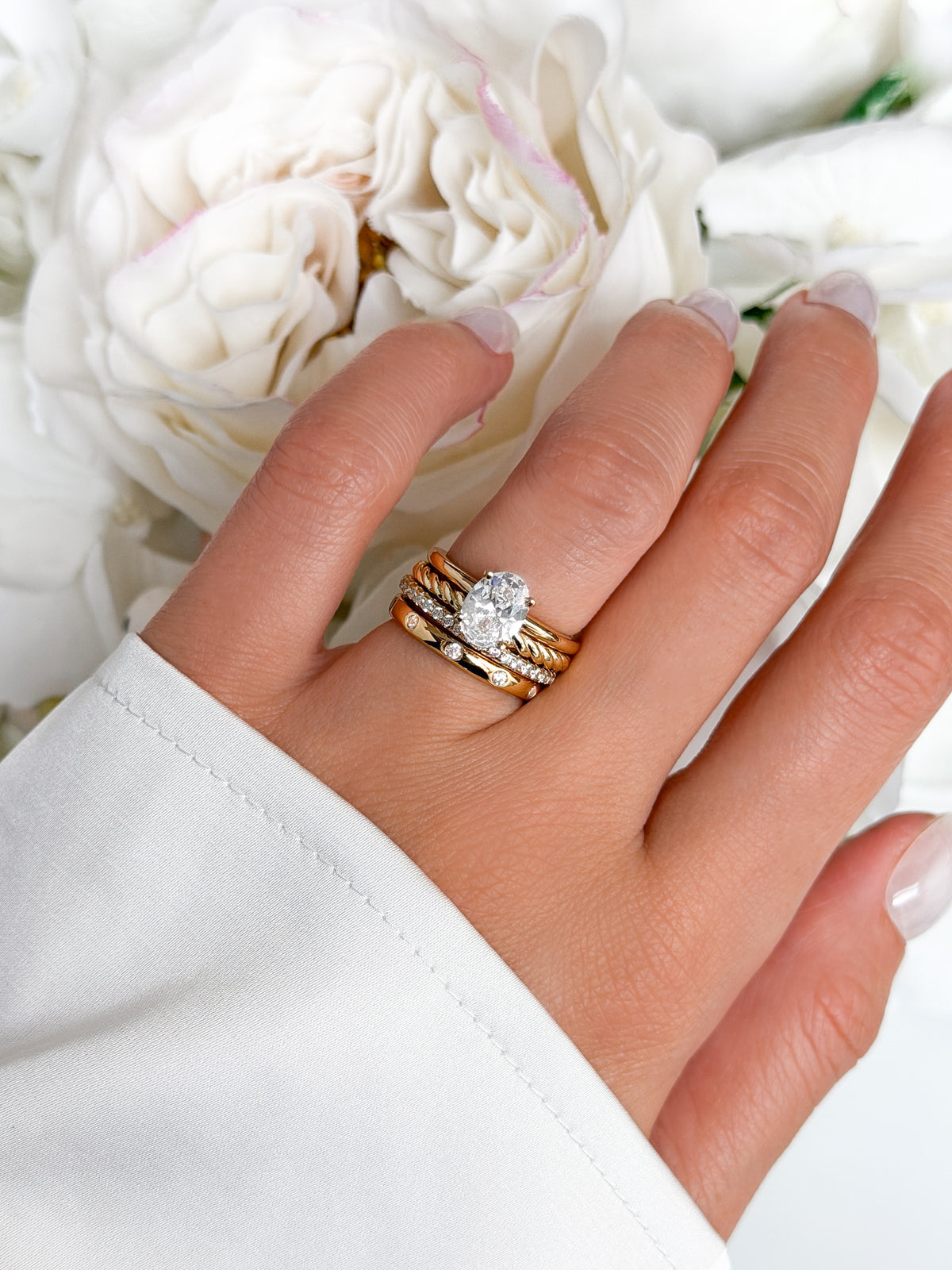 Gold engagement ring stack with oval solitaire