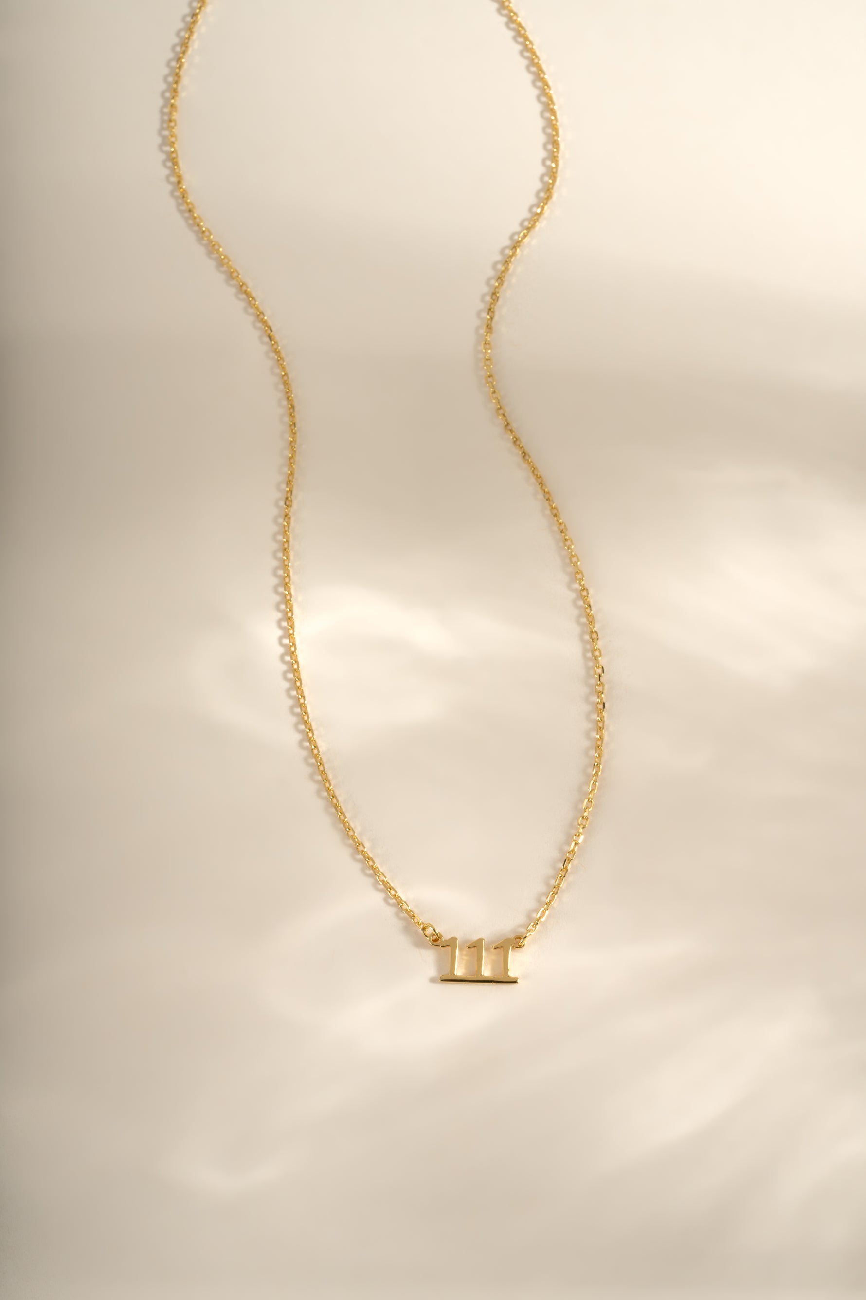 Gold angel number necklace from Sami Jewels featuring a delicate chain and a pendant with the number 111.
