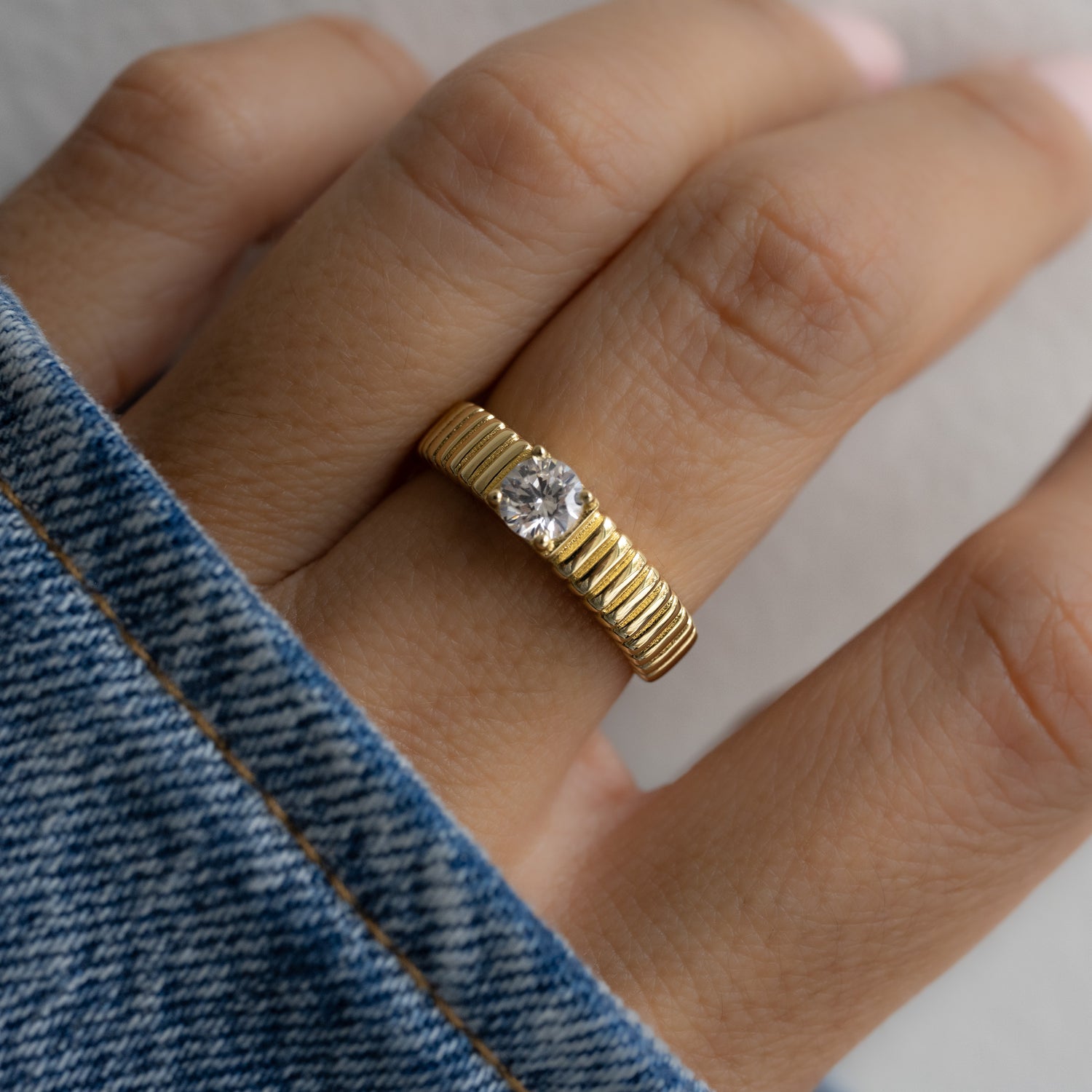 model wearing stacking ring with delicate, raised edges, offering a lightly grooved feel when worn. 