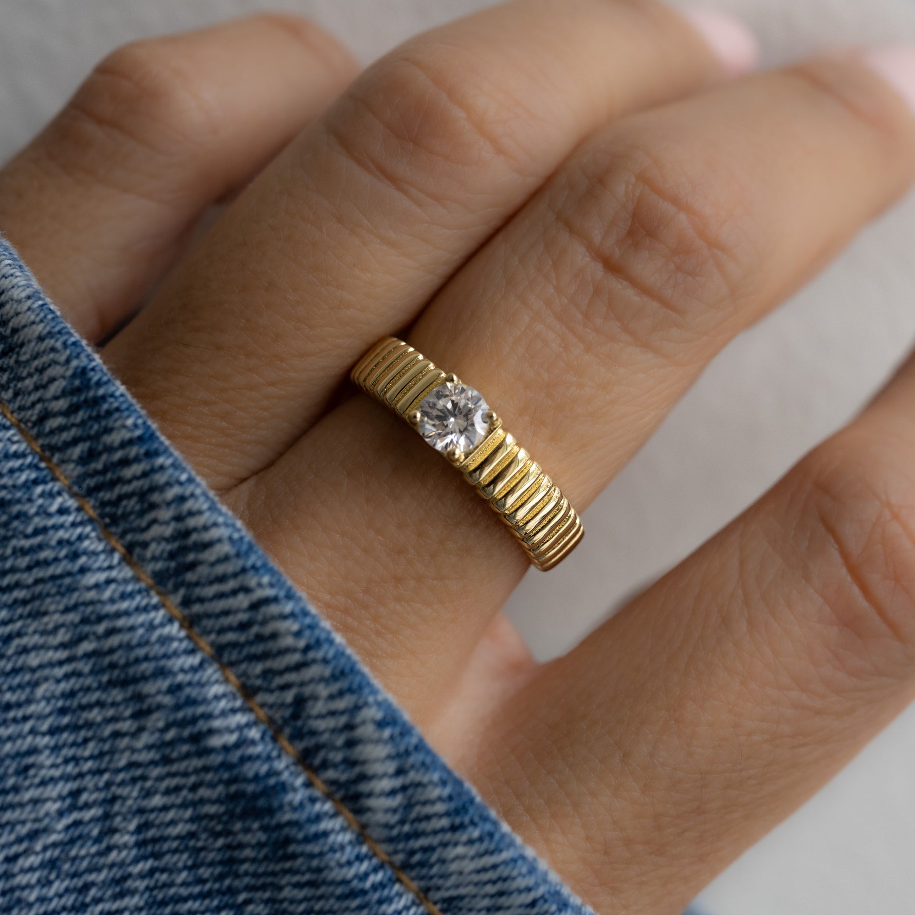 model wearing stacking ring with delicate, raised edges, offering a lightly grooved feel when worn. 