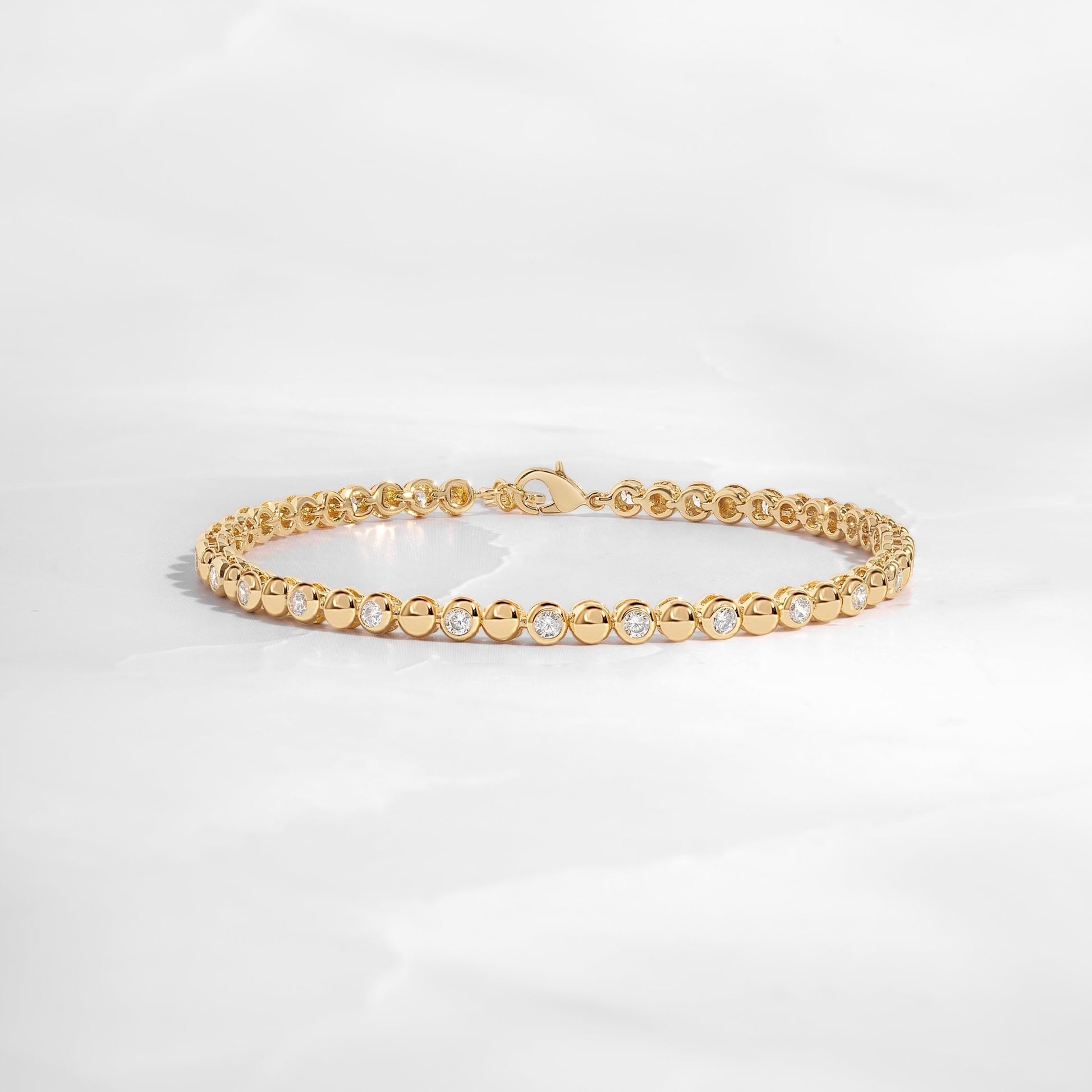 Gold bezel cz tennis bracelet on white background