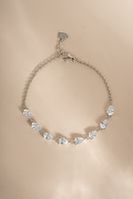 Half tennis bracelet with pear cut cubic zirconia stones set on a beige background