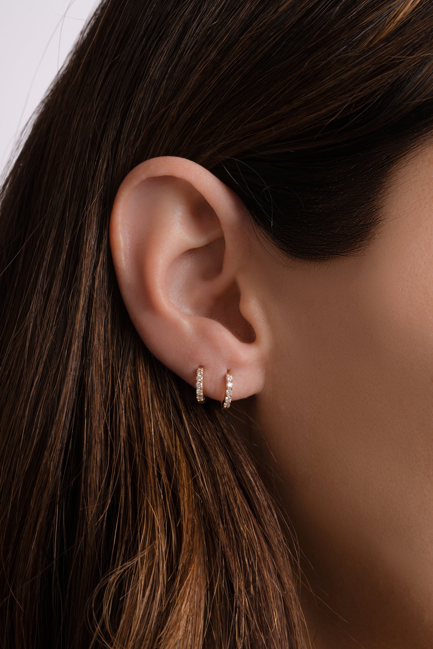 14K solid gold 7mm diamond huggie earrings stacked on ear