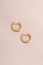 Pair of 14K solid gold 8mm pavé diamond huggie hoop earrings flat lay