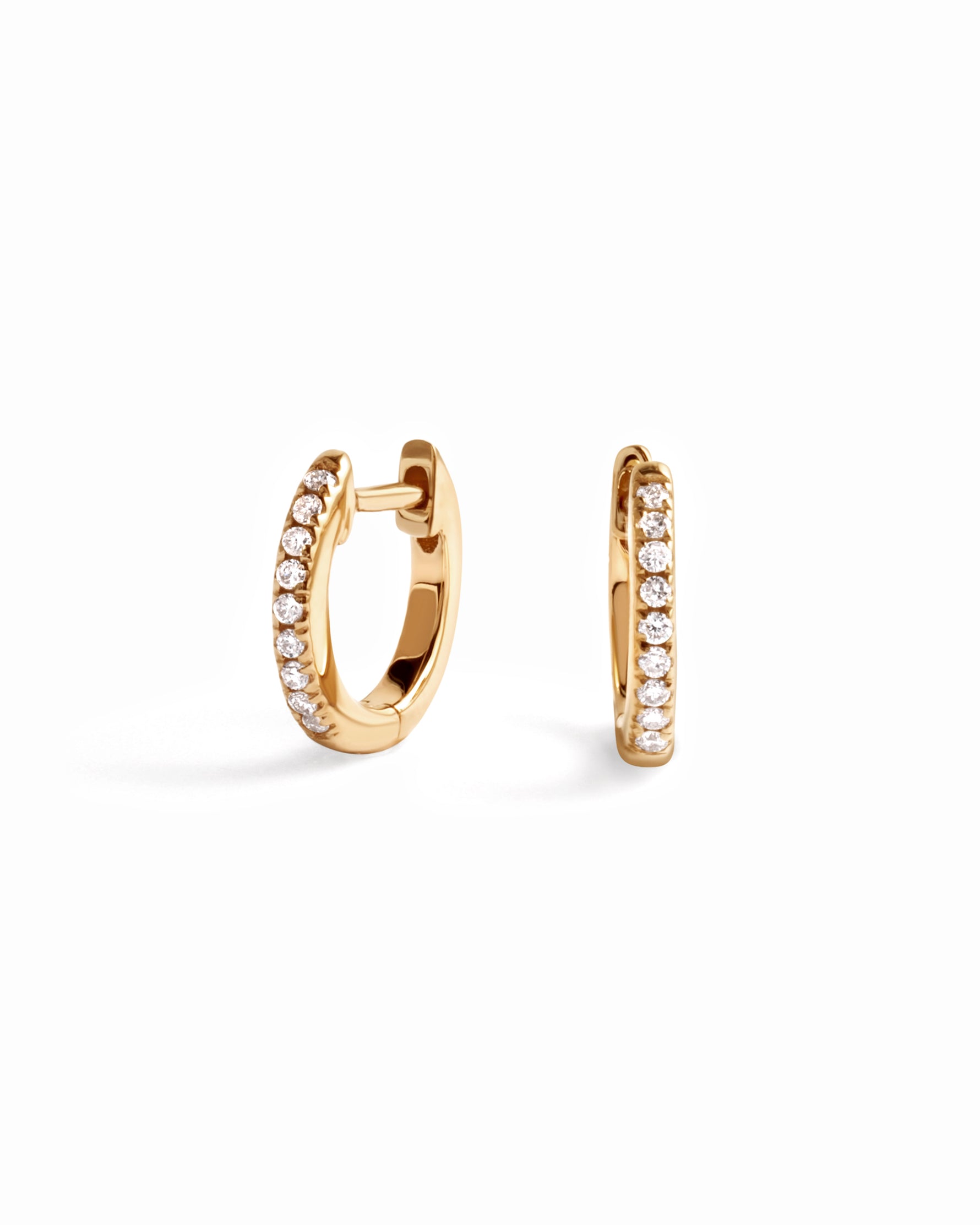 14K solid gold 8mm pavé diamond huggie earrings on white background
