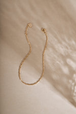 14K solid gold bar station chain bracelet styled flat lay on neutral background