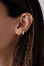 14K solid gold chunky huggie earrings from Sami Jewels, featuring a bold, rounded design on a model.