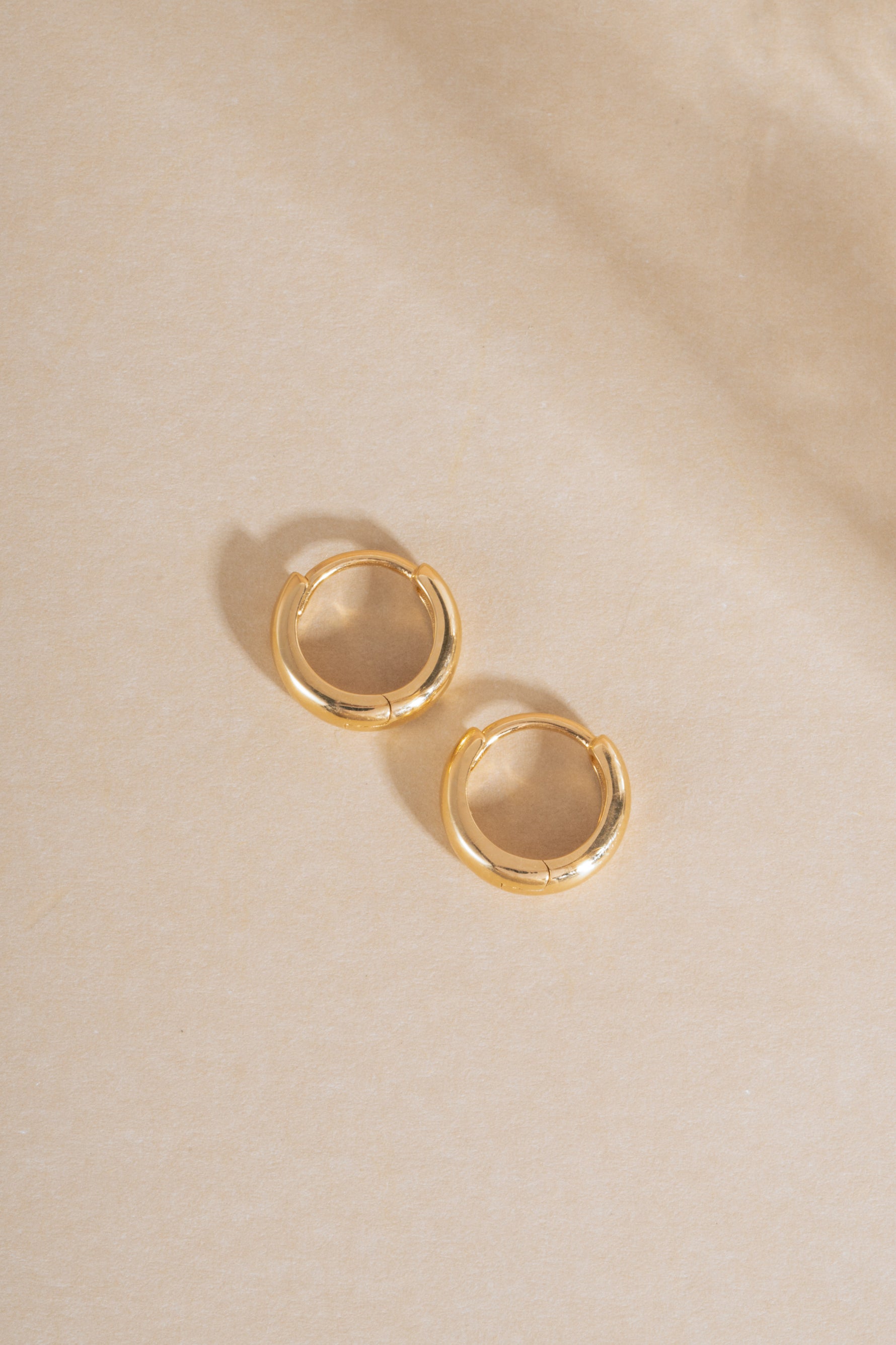14K solid gold chunky huggie hoop earrings with a bold profile, featuring a sleek and modern design by Sami Jewels.