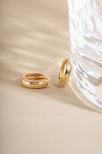 14K solid gold chunky huggie hoop earrings by Sami Jewels, close-up view showing the bold, shiny gold design.