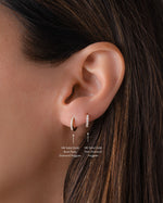 Close-up of an ear wearing a 14K solid gold 8mm diamond hoop earring stacked with product details