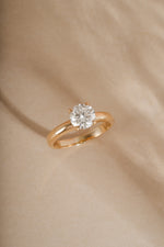 Classic round solitaire lab grown diamond ring in solid 14k gold on beige background