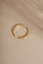 Angled view 14K solid gold wedding band with real diamonds on neutral background