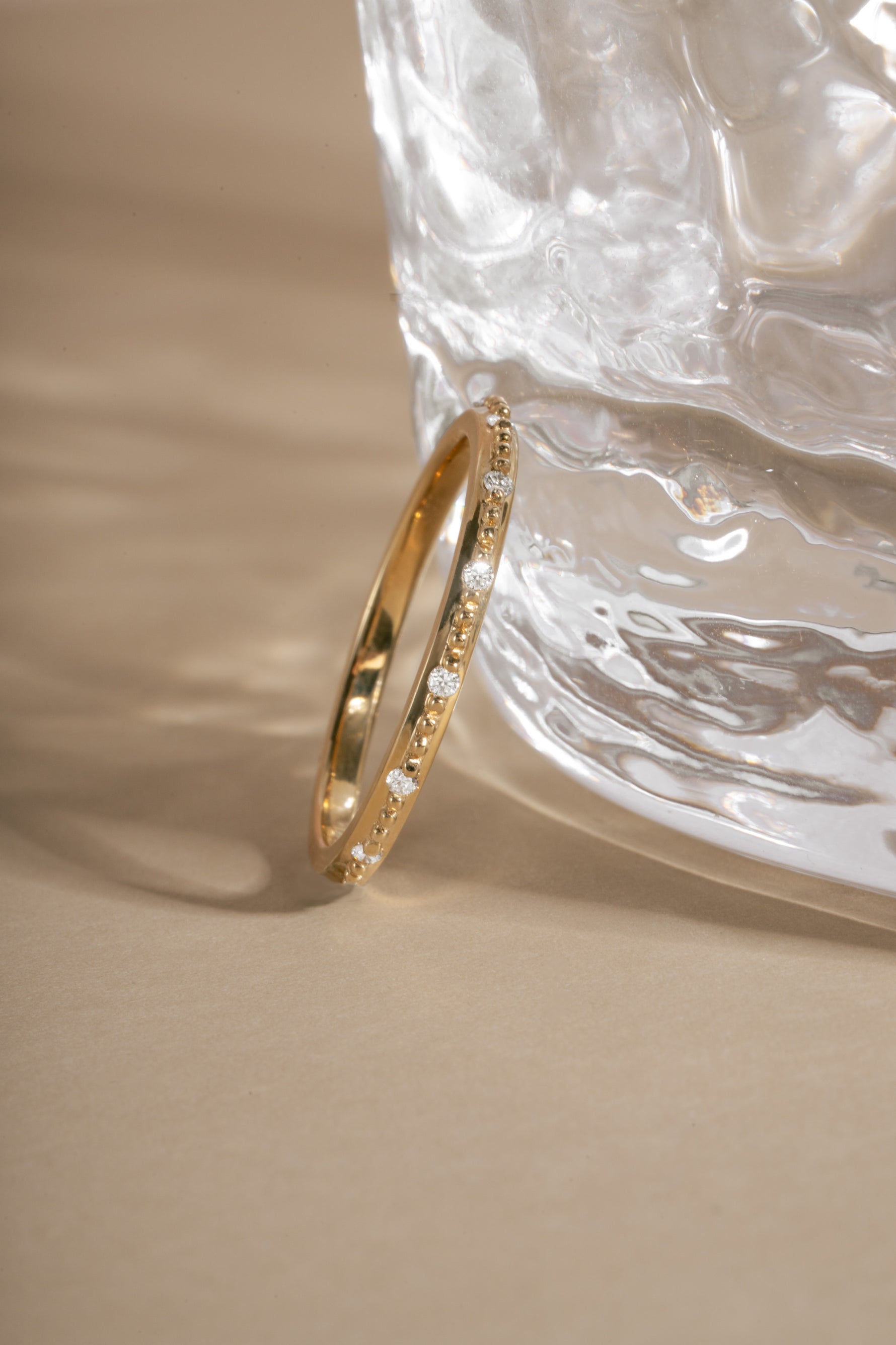 Close-up of 14K solid gold dainty ring with lab grown diamonds with neutral background