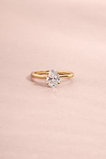 Solid 14k yellow gold oval solitaire lab diamond ring styled for fine jewelry on light pink background