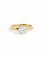 Solid 14k gold round solitaire lab diamond ring on white background