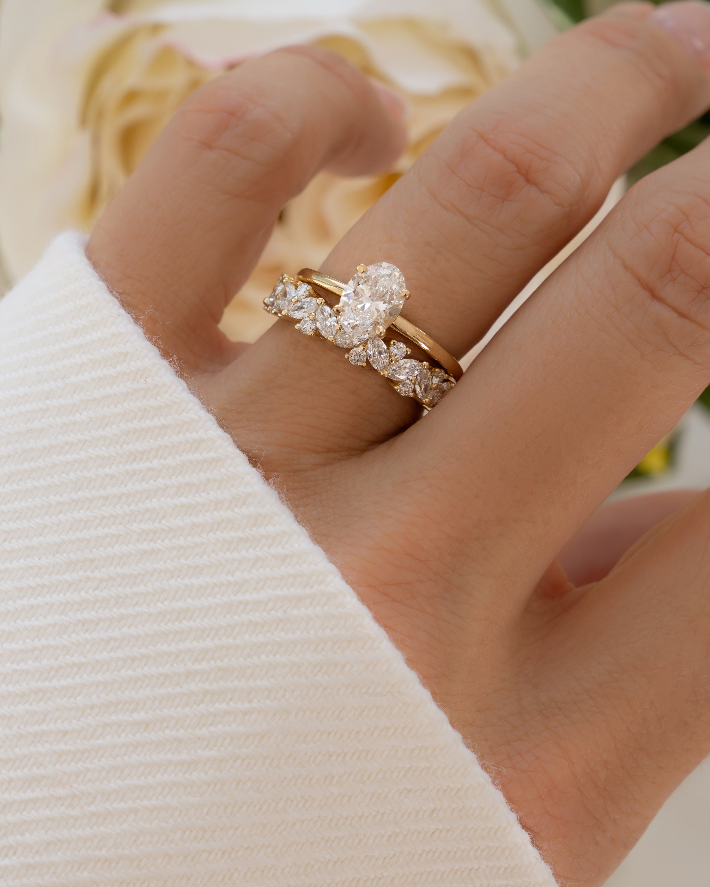 Solid 14k yellow gold oval diamond solitaire ring worn on hand with multi stone wedding ring