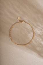 14K solid gold twisted rope chain bracelet featuring a delicate rope design on neutral background