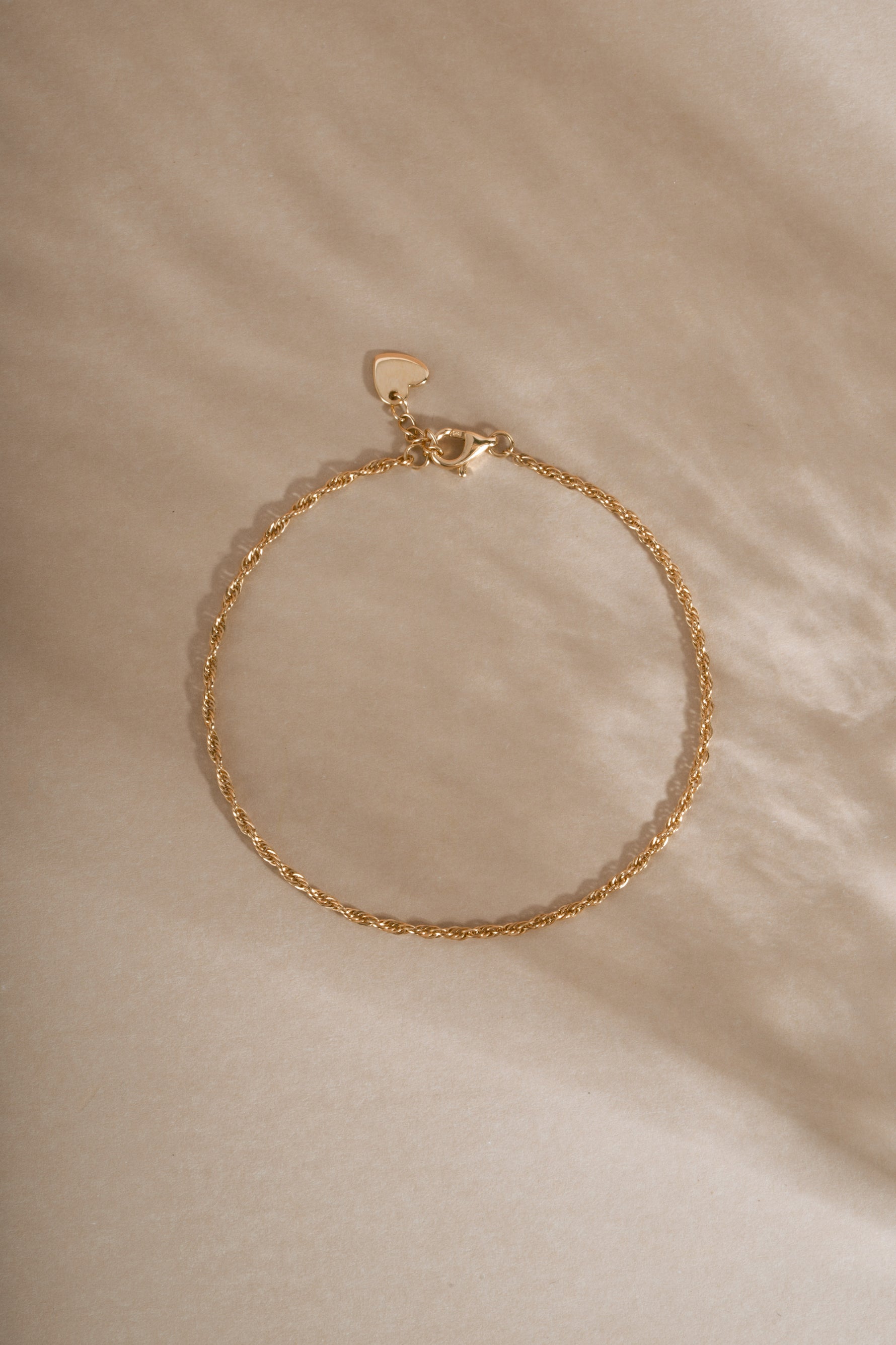 14K solid gold twisted rope chain bracelet featuring a delicate rope design on neutral background