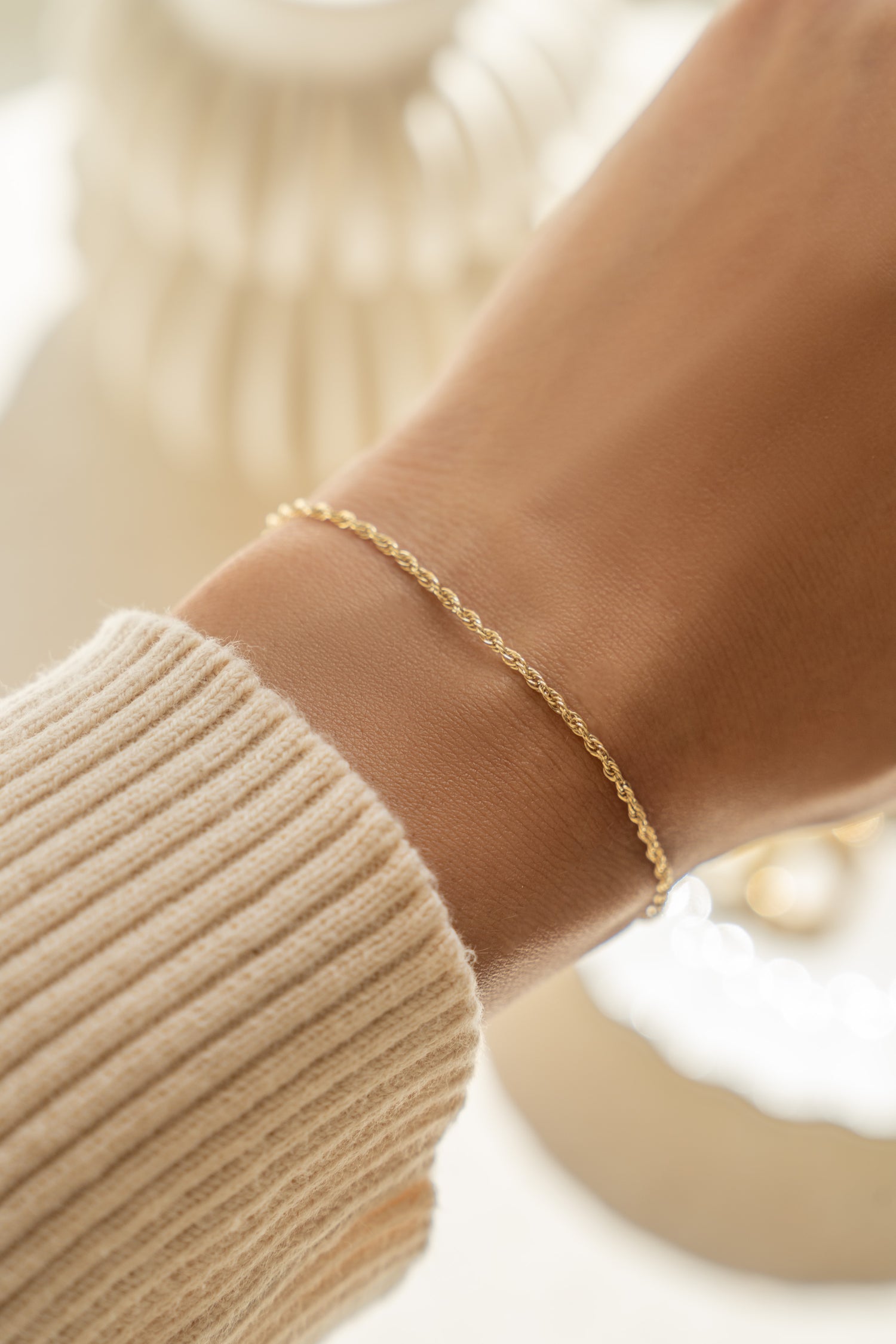 14K solid gold twisted rope chain bracelet worn on wrist