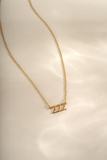 Gold angel number necklace featuring the number 222, designed by Sami Jewels, showcasing a delicate chain and pendant.