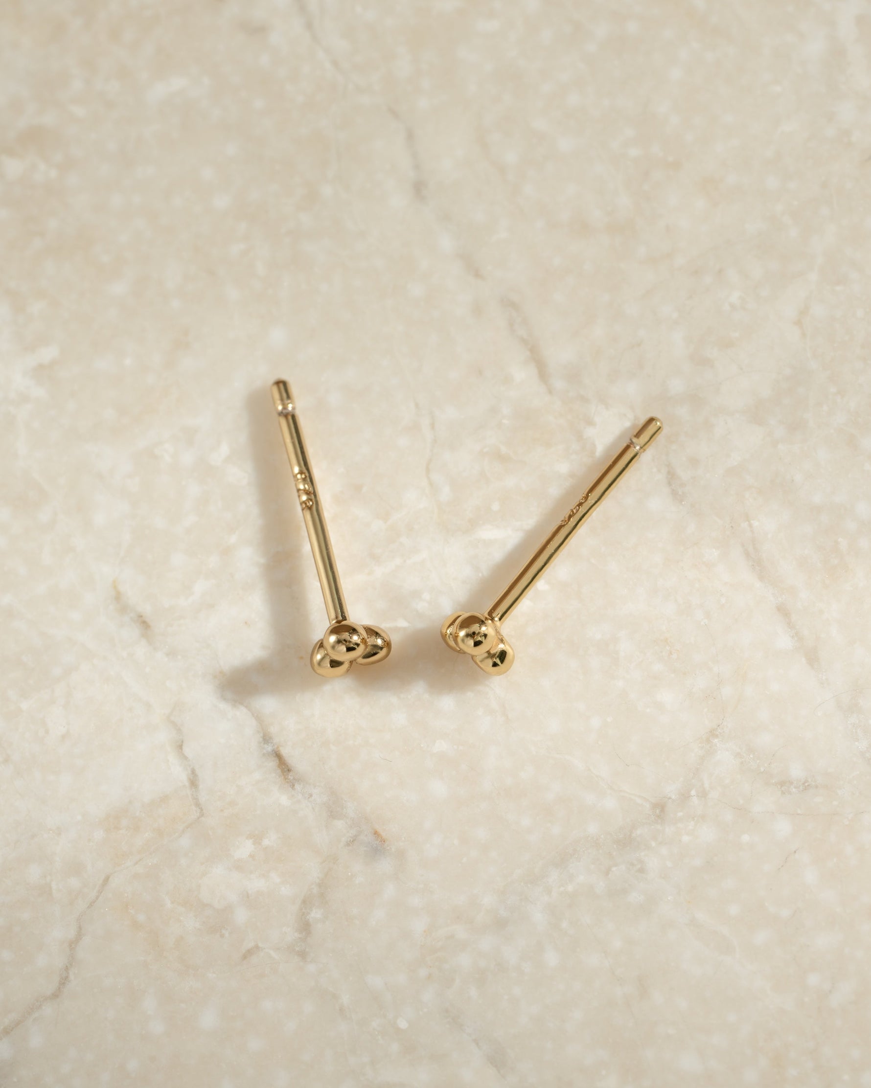 Gold 3-ball stud earrings by Sami Jewels, close-up profile view showing their simple, elegant design.