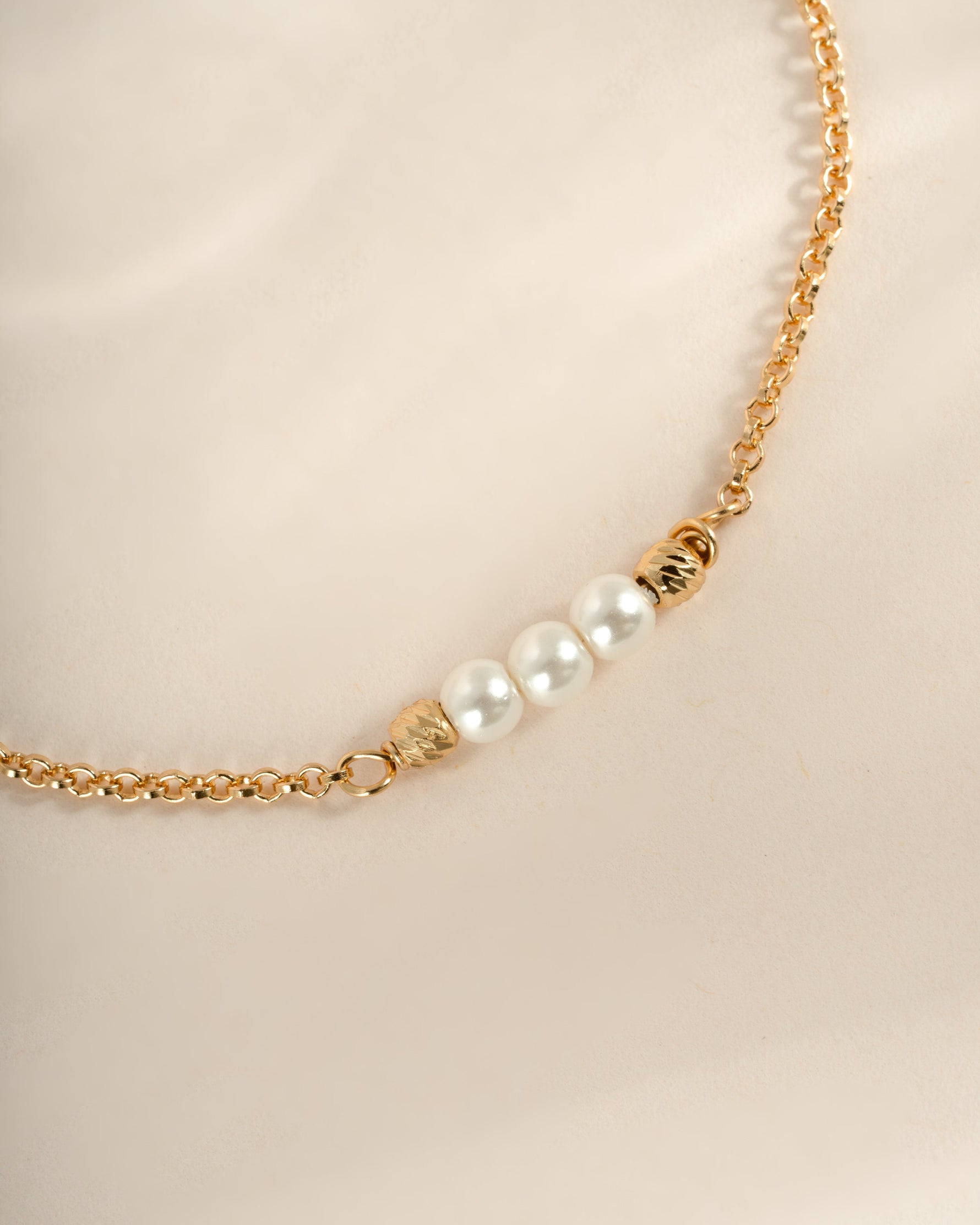 Elegant gold bracelet with three white pearls from Sami Jewels, showcasing a delicate and sophisticated jewelry piece.
