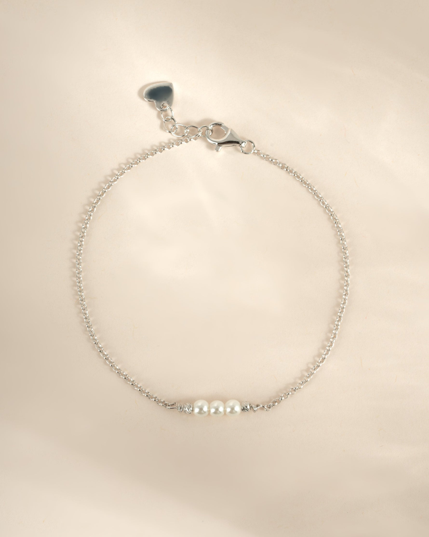 Close-up of a Sami Jewels sterling silver bracelet featuring three elegant white pearls, showcasing its delicate craftsmanship.