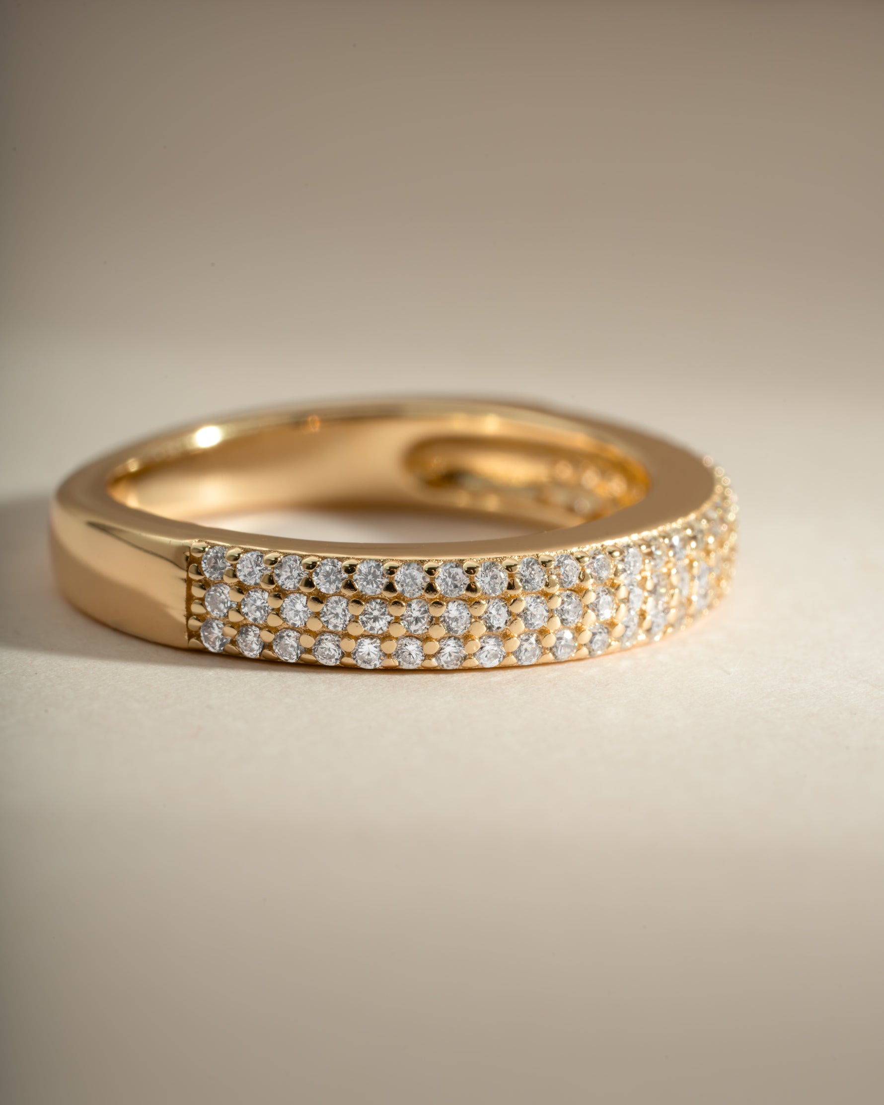 Close-up of a gold 3-row diamond ring by Sami Jewels, showcasing sparkling diamonds and intricate band design.