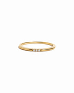 3 stone cubic zirconia stacking ring in gold on a white background