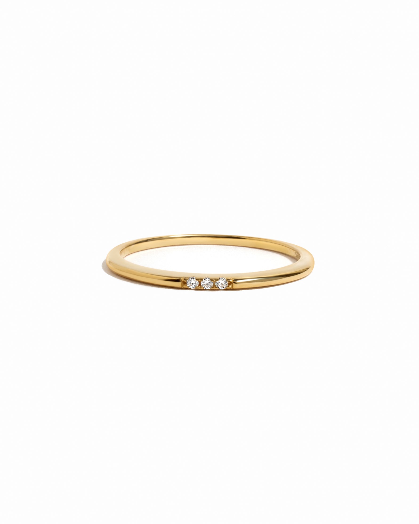 3 stone cubic zirconia stacking ring in gold on a white background