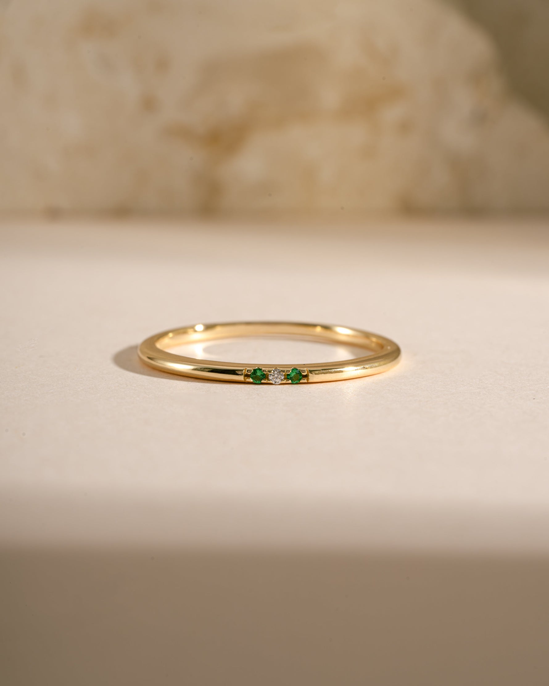 3 stone emerald ring in gold closeup view