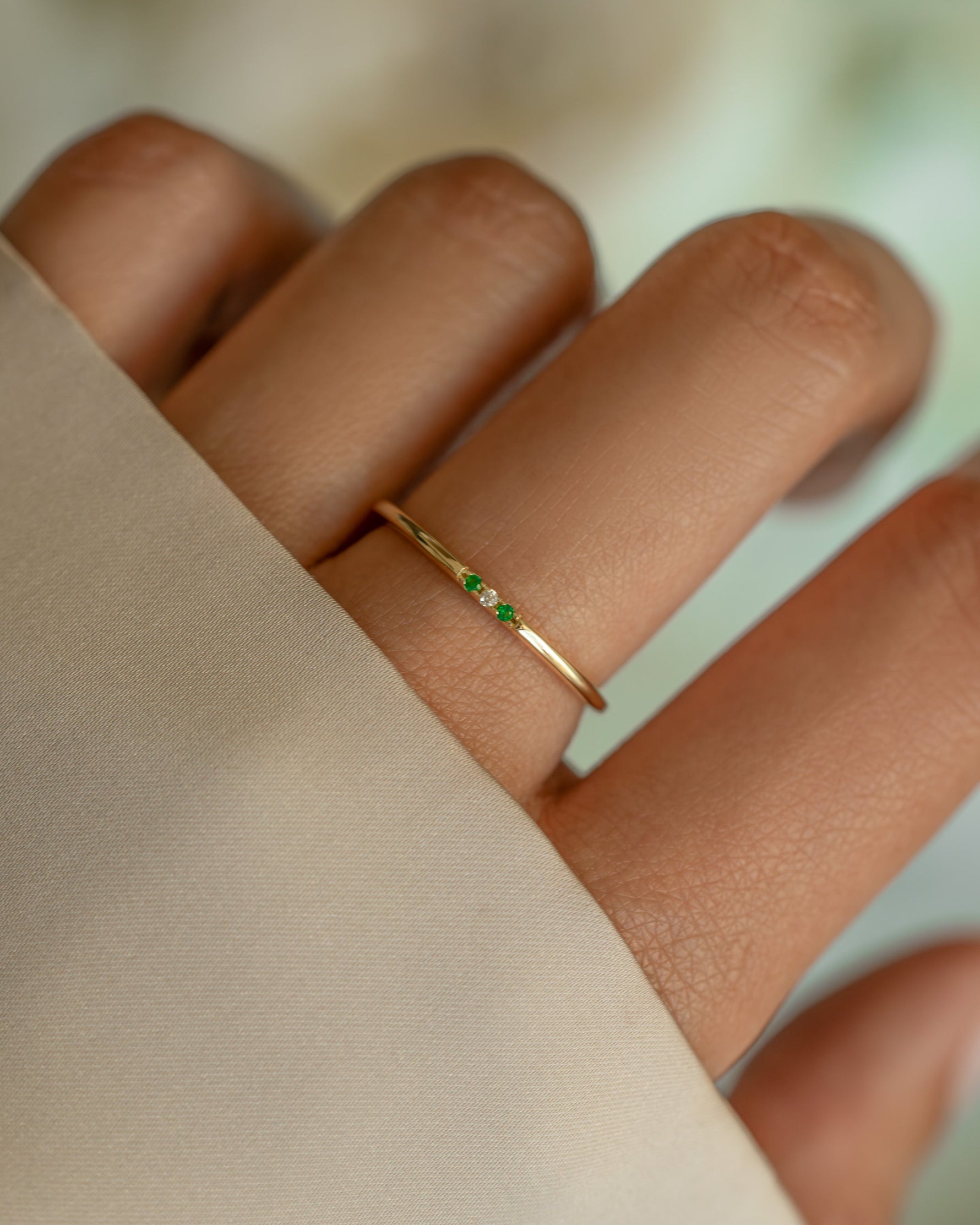 3 stone emerald ring in gold on models hand
