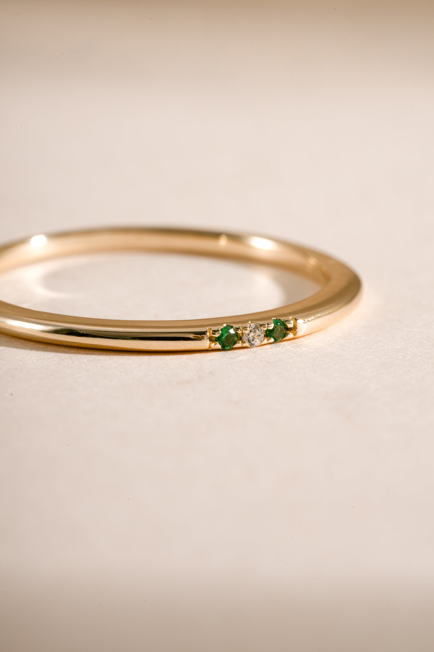 3 stone emerald ring in gold closeup