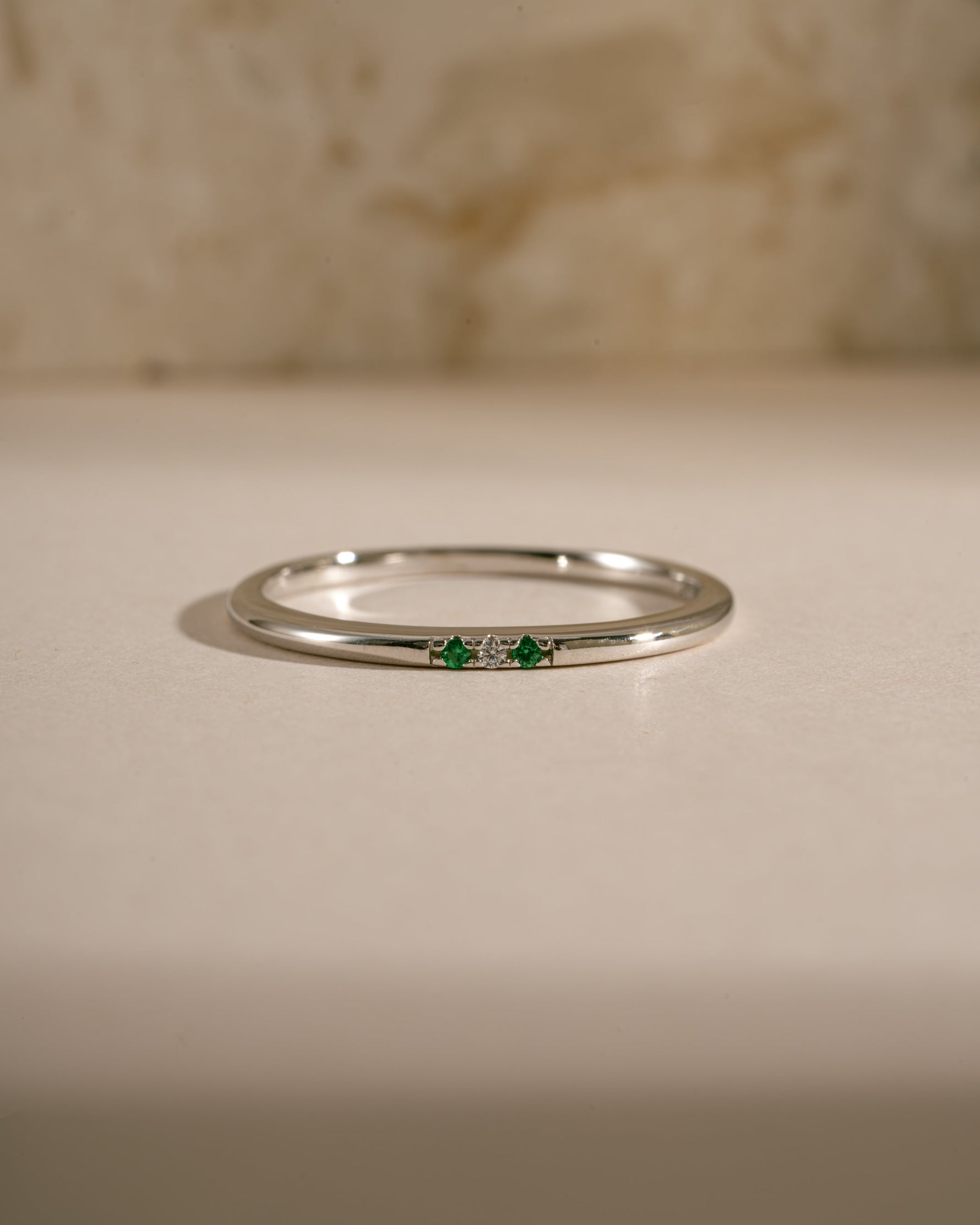 3 stone emerald ring in sterling silver on neutral background 