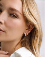 Gold Bella 3 Stone Huggie Hoops earrings by Sami Jewels, featuring three sparkling stones on small hoop earrings.