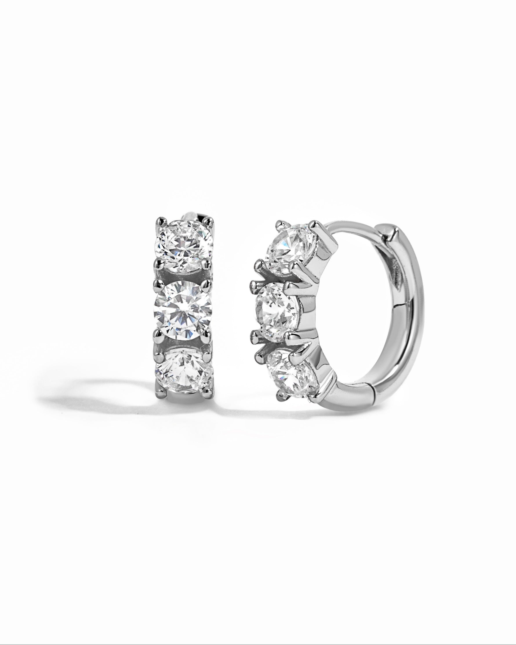 Sterling silver Bella 3 Stone Huggie Hoops earrings with three sparkling stones on a white background.